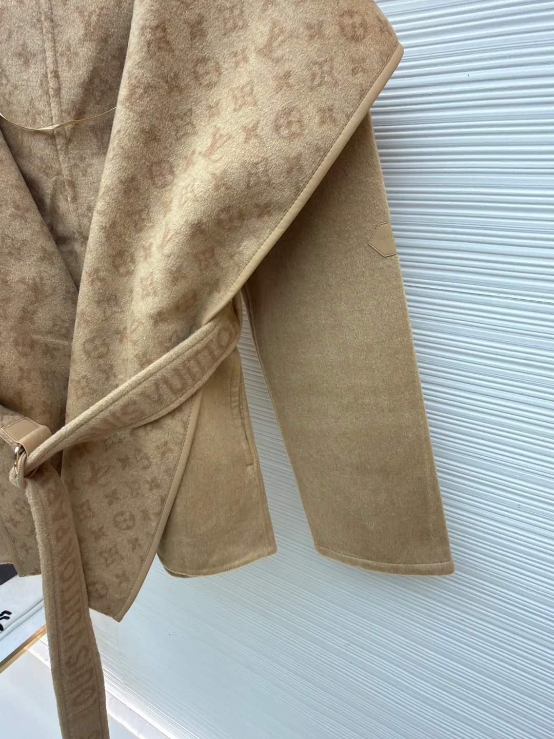 LOUIS VUITTON Wool lace-up wrap hooded coat (short style) ●Item number: 1682300-I45 ●Fabric: wool fabric ●Technology: jacquard production ●Color: khaki ●Version: loose fit ●Weight: about 1320 grams ●Size: 34-36-38-40 ●Description: This presbyopic wool coat is made of double-sided blended wool fabric imported from Italy. The main part is made of high-density matte black wool, which has been pre-shrunk and steam-set to ensure that the fabric is stiff and not easily deformed. The large lapel and belt areas use jacquard weaving technology to present the classic presbyopic pattern as a three-dimensional texture. The pattern is digitally positioned and plated to ensure that the texture is symmetrical and clear. The body of the garment is unlined and double-sided sewn to reduce the weight of the garment while improving skin-friendliness. The cuffs and hem are hand-stitched to reveal exquisite details. The waist is customized with a wide belt of the same fabric, with an adjustable buckle design with invisible stitching, allowing the silhouette to be freely adjusted; the neckline adopts a double-layer composite structure, combined with the fixation process of hand-made arch stitches, to make the large lapels more three-dimensional. Every splicing follows the precision sewing standard of 1cm/8 stitches, perfectly integrating craftsmanship and design aesthetics. The overall wiring is straight and delicate, the fabric is comfortable and soft, and the color is consistent without color difference. It can be matched with the same style to create a fashionable look and control various occasions. Customized accessories, complete with three standards, same style for men and women!